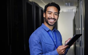 smiling-man-using-tablet-in-a-server-room